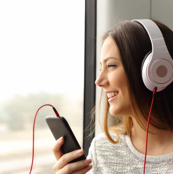A woman listens to headphones while riding on a charter bus